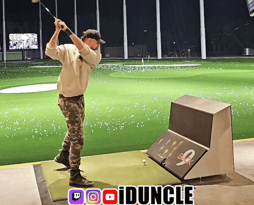 A Man Swings A Golf Club On A Driving Range With A Twitch Logo In The Upper Right Corner GIF