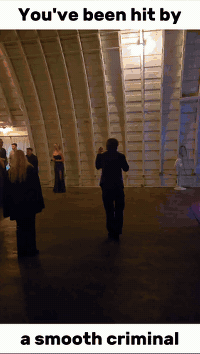 a man taking a picture of a group of people with the caption " you 've been hit by a smooth criminal " at the bottom