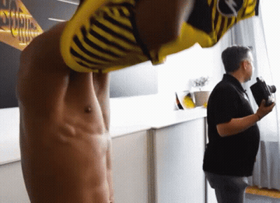 A Man Taking A Picture Of A Man In A Yellow And Black Striped Shirt With The Word Borussia On The Back GIF