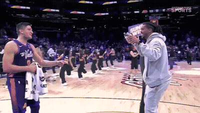 A Man Taking A Picture Of A Player With A Sign That Says Suns Win GIF