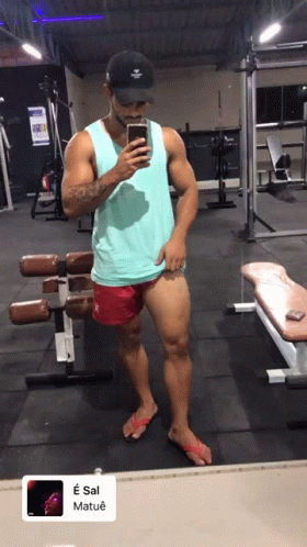 A Man Taking A Picture Of Himself In A Gym With A Sticker That Says E Sal Matue GIF