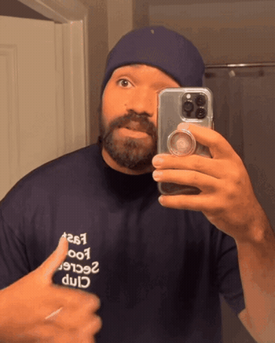 A Man Taking A Picture Of Himself In A Mirror GIF