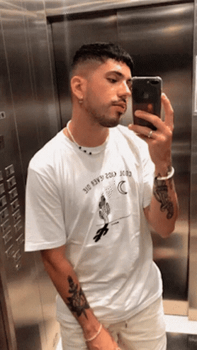 A Man Taking A Picture Of Himself In An Elevator Wearing A Shirt That Says ' 310 ' On It GIF