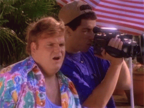 A Man Taking A Picture With A Camera While Another Man Watches GIF