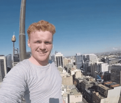 A Man Taking A Selfie In Front Of A City GIF