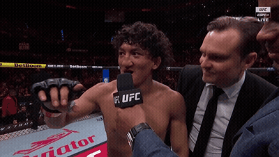 A Man Talking Into A Microphone With The Word Ufc On His Chest GIF