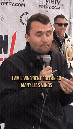 A Man Talking Into A Microphone With The Words " I Am Living Rent Free In So Many Libs Minds " GIF