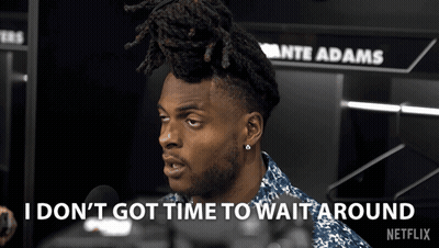 A Man Talking Into A Microphone With The Words " I Don 'T Got Time To Wait Around " Behind Him GIF