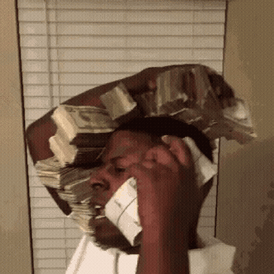 A Man Talking On A Cell Phone With A Stack Of Money On His Head GIF