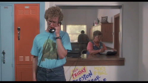A Man Talking On A Phone In Front Of A Sign That Says Friday Preston GIF