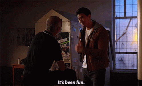 A Man Talking To Another Man In Front Of A Locker With A Poster That Says " It 'S Been Fun " On It GIF