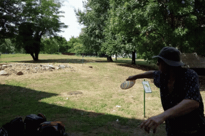 A Man Throwing A Frisbee In A Park With A Sign That Says ' A Few Steps ' On It GIF