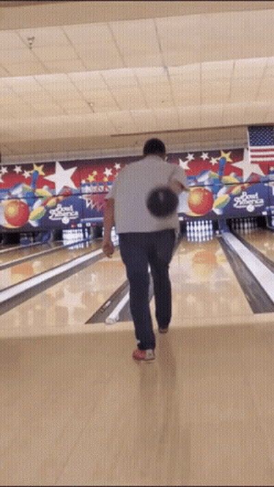 A Man Throws A Bowling Ball In A Bowling Alley That Says Bowl America On The Wall Behind Him GIF