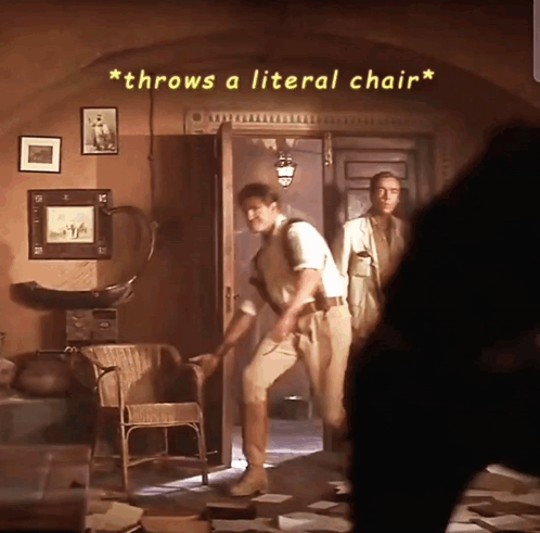 A Man Throws A Literal Chair While Another Man Watches GIF