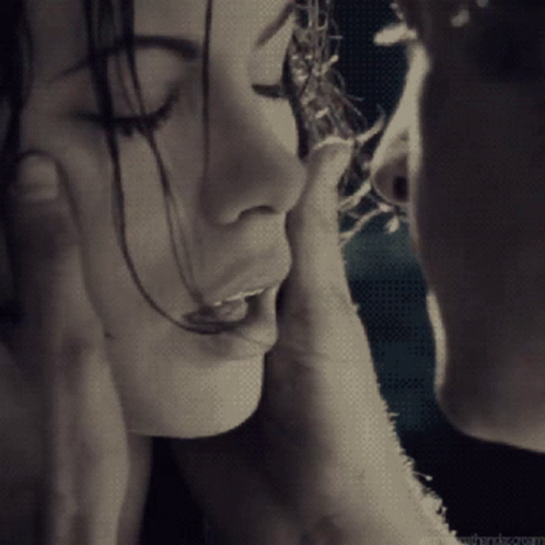 A Man Touches A Woman 'S Face With His Hand GIF