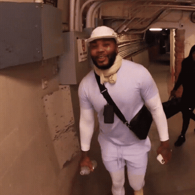 A Man Walking Down A Hallway With A Sign That Says No Smoking GIF