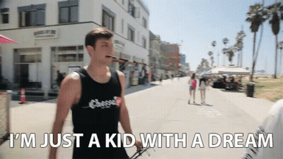 A Man Walking Down A Street With The Words " I 'M Just A Kid With A Dream " On The Bottom GIF