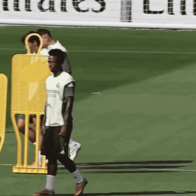 A Man Walking On A Soccer Field In Front Of A Sign That Says ' Emirates ' GIF