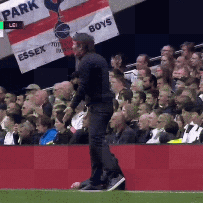 A Man Walking On A Soccer Field With A Banner That Says Essex Boys GIF
