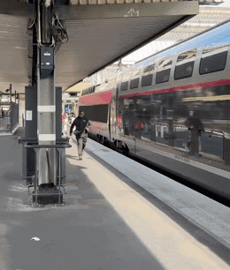A Man Walking Towards A Train That Has The Number 41 On It GIF