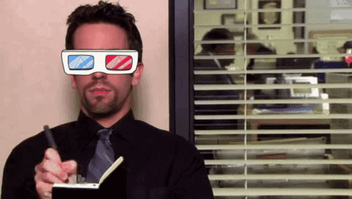 A Man Wearing 3D Glasses Is Holding A Pen And Writing In A Notebook GIF
