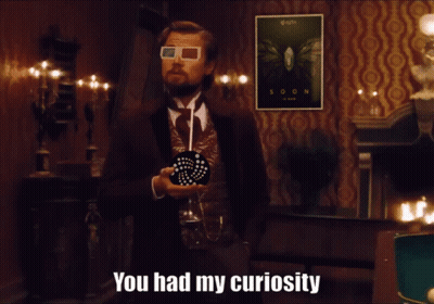 A Man Wearing 3D Glasses Stands In Front Of A Soon Poster GIF