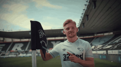 A Man Wearing A 32 Ed Jersey Points To A Flag GIF