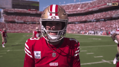 A Man Wearing A 49Ers Jersey And Helmet Stands On A Football Field GIF