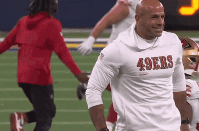 A Man Wearing A 49Ers Shirt Is Smiling On The Field GIF