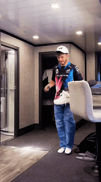 A Man Wearing A Alpine Shirt Stands In A Room GIF