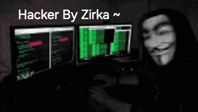 A Man Wearing A Anonymous Mask Is Sitting In Front Of A Computer Monitor . GIF