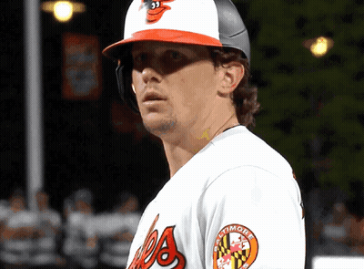 A Man Wearing A Baltimore Orioles Jersey Looks To The Side GIF