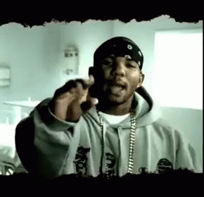 A Man Wearing A Bandana And A Hoodie Is Giving A Speech . GIF
