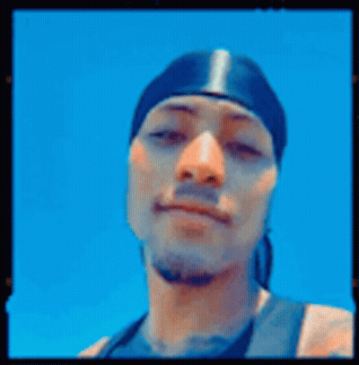 A Man Wearing A Bandana Is Giving A Peace Sign . GIF