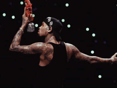 A Man Wearing A Bandana With The Number 99 On It Holds A Bottle Of Water In His Hand GIF
