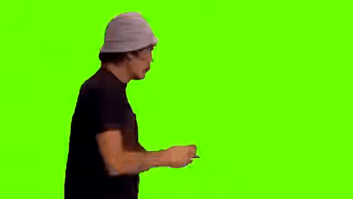 A Man Wearing A Baseball Cap And A Black Shirt Is Dancing On A Green Screen . GIF