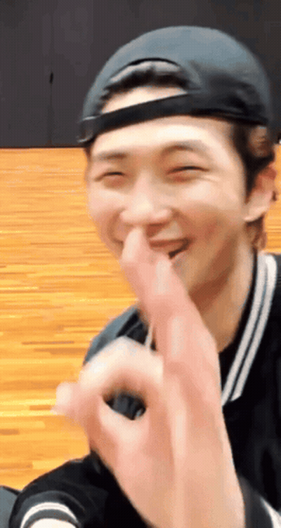 A Man Wearing A Baseball Cap Is Making A Heart With His Fingers GIF
