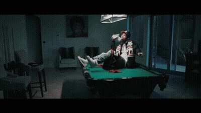 A Man Wearing A Baseball Cap Is Sitting On A Couch Holding A Stack Of Money . GIF