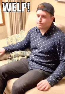 A Man Wearing A Baseball Cap Is Sitting On A Couch With The Word Welp Written Above Him . GIF