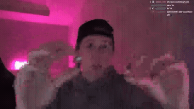 A Man Wearing A Baseball Cap Is Smiling In Front Of A Pink Background GIF