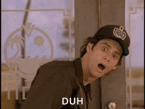 A Man Wearing A Baseball Cap Is Standing In Front Of A Door With His Mouth Open And Says Duh . GIF
