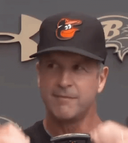 A Man Wearing A Baseball Cap With An Angry Bird On It Is Making A Funny Face . GIF