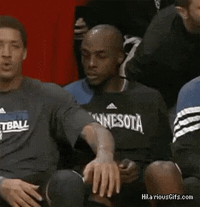 A Man Wearing A Basketball Shirt Is Sitting On The Bench GIF