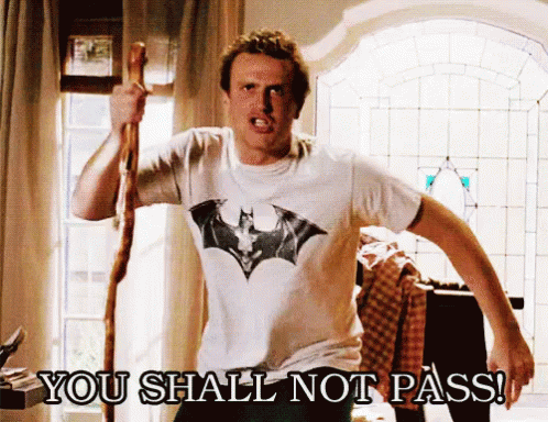 A Man Wearing A Batman T-Shirt Is Holding A Cane And Says You Shall Not Pass GIF
