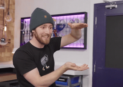 A Man Wearing A Beanie And A Black T-Shirt With A Camera On It GIF