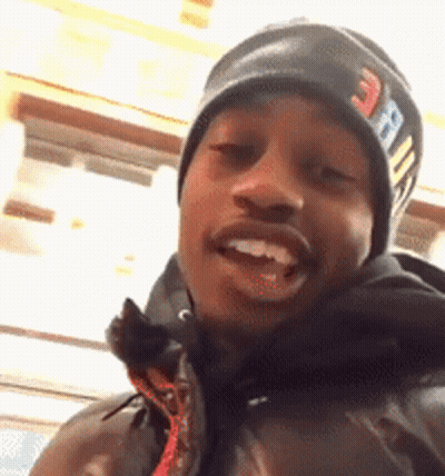 A Man Wearing A Beanie And A Jacket Is Smiling For The Camera GIF