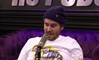 A Man Wearing A Beanie And A Shirt That Says Bad On It GIF