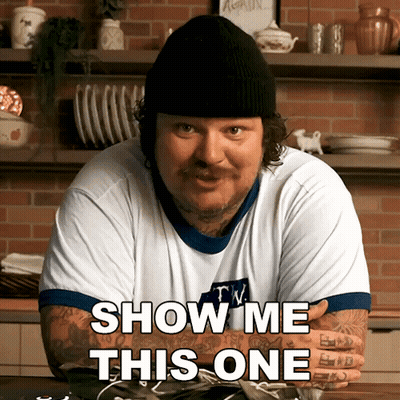 A Man Wearing A Beanie And A T-Shirt That Says Show Me This One GIF