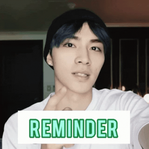 A Man Wearing A Beanie And A White Shirt Has A Sign That Says Reminder On It GIF