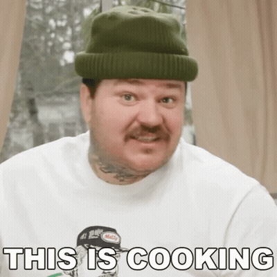 A Man Wearing A Beanie And A White Shirt Says This Is Cooking GIF